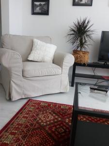 a living room with a white couch and a table at Apartman "Noa" in Sremska Mitrovica