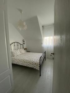 a bedroom with a bed in a white room at Apartman "Noa" in Sremska Mitrovica
