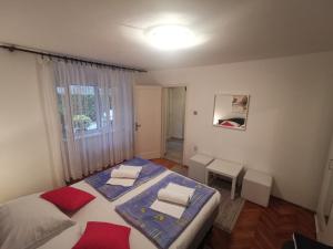 a small bedroom with two beds and a window at Apartment Dino in Novi Vinodolski