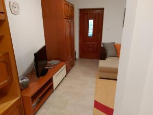 sala de estar con TV y sofá en Nyugalom szigete 2 fős apartman 1 hálótérrel, en Vértessomló