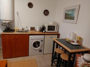 cocina con lavadora y microondas en Nyugalom szigete 2 fős apartman 1 hálótérrel, en Vértessomló