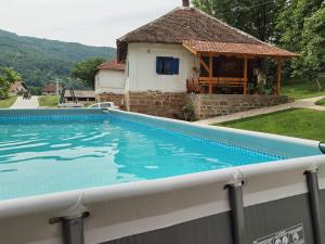 a swimming pool in front of a house at Etno kuća Radonjić - Family Retreat & Spa in Guča
