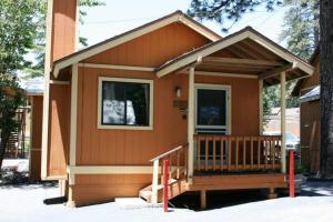a small house with a porch and a deck at Sleepy Hollow Cabins & Hotel in Crestline