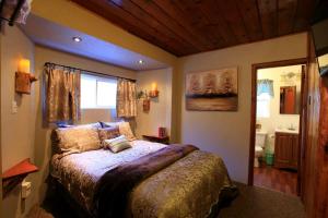 a bedroom with a bed and a window and a bathroom at Sleepy Hollow Cabins & Hotel in Crestline