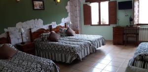 ウルエニャにあるPozolico Hotel Ruralのベッドルーム1室(ベッド2台、テーブル、椅子付)