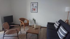 sala de estar con sofá, mesa y sillas en L'Amaryllis, beau T4 contemporain et lumineux en Centre Ville 3 étoiles, en Sète