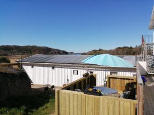 un bâtiment avec une clôture et un parapluie bleu dans l'établissement Bottna Inn, à Gerlesborg