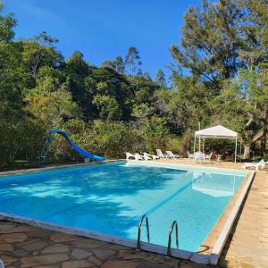 a swimming pool with a slide in the middle at Park Hotel Mantiqueira in Barbacena