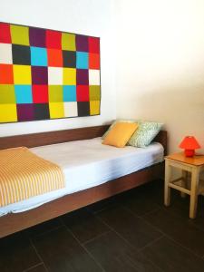 Ce lit se trouve dans un dortoir orné d'une peinture colorée sur le mur. dans l'établissement River-view studio perfect for travelers, à Metković