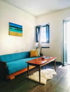 - un salon avec un canapé bleu et une table dans l'établissement River-view studio perfect for travelers, à Metković