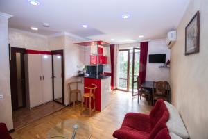 a kitchen and living room with red cabinets and a table at Comfortable apartment in Yerevan