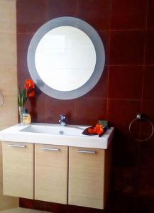 a bathroom with a sink and a round mirror at La Vatura in Gialova