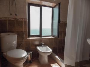 a bathroom with a toilet and a window at Guest house Naser in Ulcinj