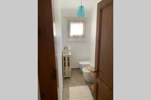 a bathroom with a toilet and a window at Appartamento IL CANNETO in Cannigione +45 photos