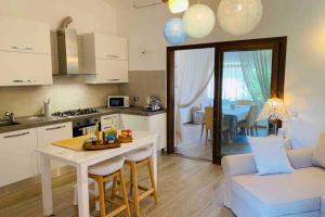 a kitchen and living room with a table and a couch at Appartamento IL CANNETO in Cannigione