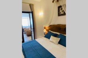 Un dormitorio con una cama azul y blanca y una ventana en Appartamento IL CANNETO en Cannigione