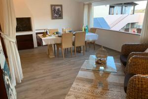 a living room with a table and a dining room at Appartamento IL CANNETO in Cannigione