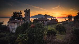 an old house on a hill with the sunset in the background at La Maison Du Lac Iseo in Predore