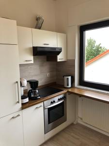 uma pequena cozinha com um fogão e uma janela em Ferienwohnung Katja em Bad Lippspringe