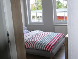 1 cama en una habitación con 2 ventanas en Apartament w Węgorzewie, en Węgorzewo