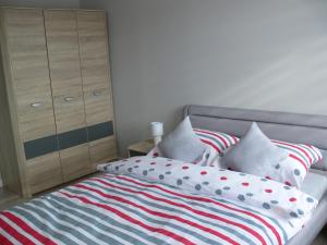 a bedroom with a bed with pillows and a dresser at Apartament w Węgorzewie in Węgorzewo