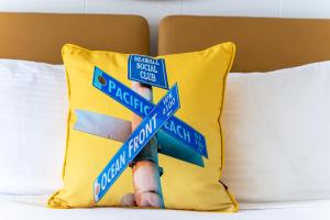 a pillow with a bunch of street signs on a bed at Ocean Park Inn in San Diego