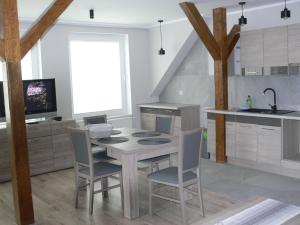 cocina con mesa, sillas y fregadero en Apartament w Węgorzewie, en Węgorzewo