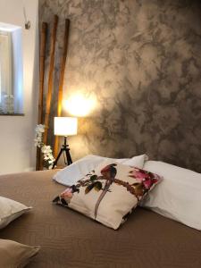 1 cama con almohada y pared en Boncompagni Suite Roma, en Roma