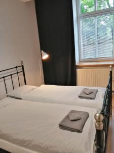 two beds sitting next to a window with towels on them at Apartament Galicja Plus in Chrzanów