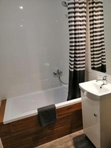 a bathroom with a white bath tub next to a sink at Apartament Galicja Plus in Chrzanów
