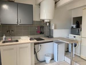 a kitchen with white cabinets and a sink at La Garde Studio centre historique, proche plage, climatisation, fibre in La Garde