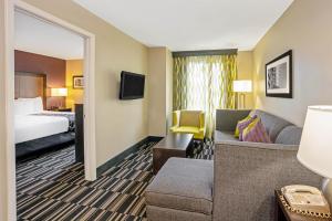 a hotel room with a couch and a bed at La Quinta Inn & Suites by Wyndham The Woodlands Spring in Spring