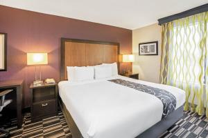 a hotel room with a large bed and a desk at La Quinta Inn & Suites by Wyndham The Woodlands Spring in Spring