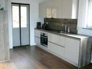 a kitchen with white cabinets and a sink at vakantiehuis Zidanica in Žužemberk