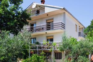 a white house with a balcony and trees at Apartment Šverko in Kastav