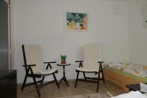 two chairs and a table and a bed in a room at Apartments and rooms Brunko in Bled