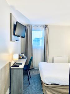 a hotel room with a bed and a desk with a television at Sure Hotel by Best Western Calais Coquelles Tunnel s/ Manche in Coquelles