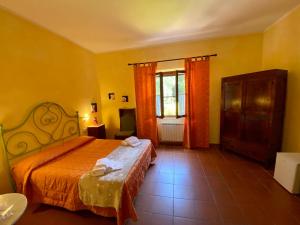 サトゥルニアにあるB&B 8380 - Pian Del Molinoのベッドルーム1室(オレンジ色のベッドカバー付)