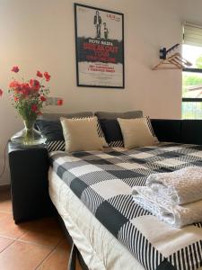 un letto in una stanza con un vaso di fiori di Mały Domek w Górach Sowich a Pieszyce