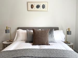 um quarto com uma cama com almofadas e 2 candeeiros em High Street, Stylish City Centre Apartment, 3 Bed em Perth