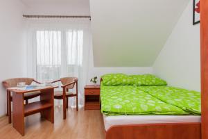 a bedroom with a bed and a table and a desk at U KAZI in Niechorze