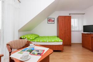 a small room with a bed and a table at U KAZI in Niechorze +16 photos