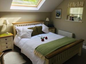 a bedroom with a bed with two roses on it at Frogmill Studio in Exeter