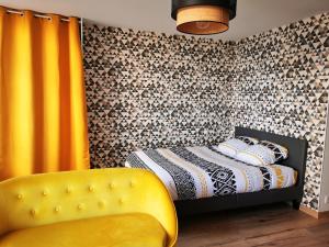 a bedroom with a bed and a yellow chair at Studio Cosy Breizh in Cancale