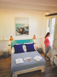 kobieta stojąca w sypialni patrząca przez okno w obiekcie Hotel Romantic Los 5 Sentidos w mieście Ciutadella