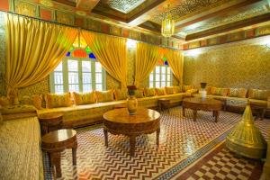 a large living room with a couch and tables at Riad Mimouna in Essaouira