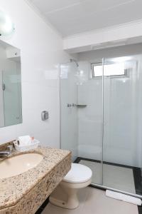 a bathroom with a shower and a toilet and a sink at Hotel Express Aeroporto in Porto Alegre