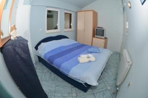 a bedroom with a large bed with a blue blanket at Rooms and Apartaments De Niro in Trpejca