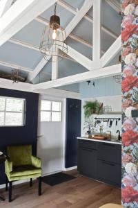 a kitchen with blue walls and a ceiling with a chandelier at Bed and Breakfast Het Emmapark Medemblik in Medemblik
