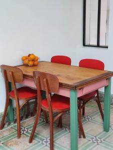 a wooden table with chairs and a bowl of fruit on it at Gîte de la Maison du L.A.C in Simard
